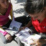 Dos jóvenes repasan el libro de conducir antes de presentarse a la prueba teórica en el centro de exámenes de la DGT