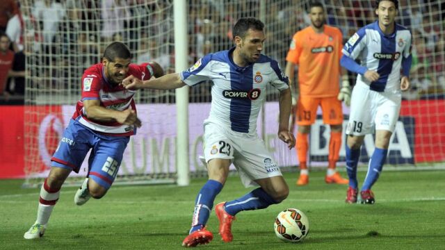 El defensa del Espanyol, Anaitz Arbilla (c), controla el balón ante el jugador argentino del Granada, Emanuel Mariano Insúa
