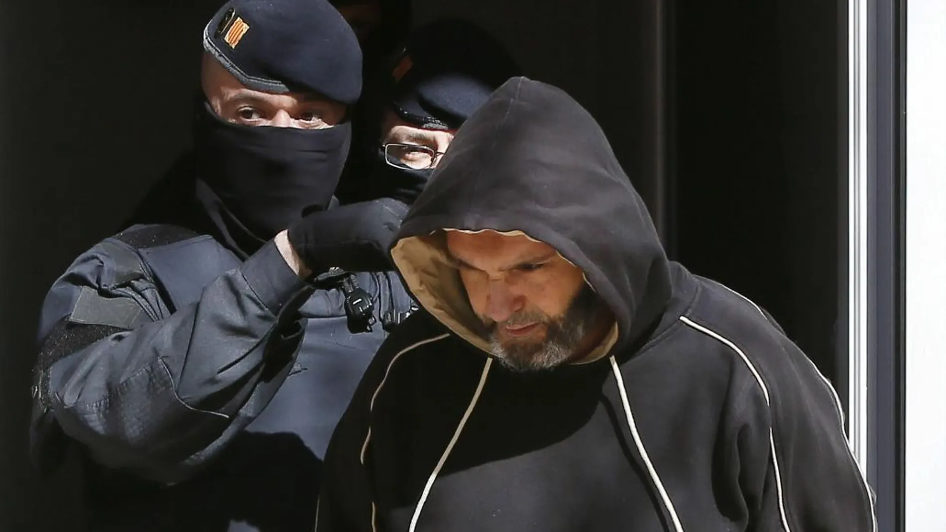 Agentes de los Mossos d'Esquadra custodian a una de las 11 personas que han sido detenidas en el marco de una operación contra el terrorismo yihadista.