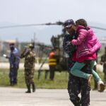 Un soldado nepalí traslada a una niña herida tras ser rescatada en Sindhupalchock, a su llegada al aeropuerto Internacional de Katmandú.