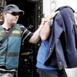 Agentes conducen a un detenido en Valencia en la sede de la empresa EICO