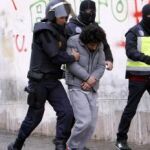 Efectivos policiales trasladan a un detenido durante una operación en Melilla contra una célula encargada del envío de yihadistas a Siria.