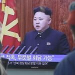 Un par de surcoreanos escuchan atentamente la retransmisión del mensaje de Año Nuevo del líder norcoreano, Kim Jong-un.