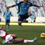 El colombiano del Sevilla Bacca y Antonio Amaya, en el suelo, del Rayo Vallecano, disputan el balón