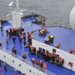 Un miembro de la tripulación de un helicóptero italiano contempla la cubierta del buque Norman Atlantic incendiado hoy.