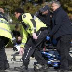 Sanitarios transportan al soldado herido junto al Canadian War Memorial.