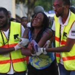 Dos sanitarios ayudan a una mujer liberada por Al Shabab, en la Universidad