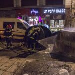 Los bomberos apagan un contenedor volcado e incendiado durante los incidentes