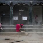 Varios trabajadores barren la plaza Hanumandhoka Durbar en Katmandú
