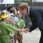 El príncipe Harry saluda a unos niños durante una visita a un colegio en Nueva Zelanda