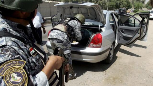 Policías iraquíes revisan un vehículo en Bagdad, Irak