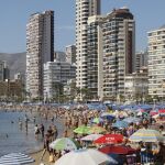 Miles de personas disfrutan de una soleada jornada en la playa de Levante de la localidad alicantina de Benidorm