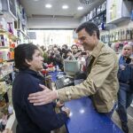 El secretario general del PSOE, Pedro Sanchez, saluda a un comerciante del distrito barcelonés de Nou Barris, adonde ha acudido para celebrar una asamblea abierta