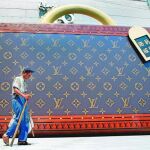 Un ciudadano chino pasa por delante de una clásica maleta de Louis Vuitton