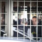 Uno de los funcionarios de la Agencia Tributaria (i) en el portal del domicilio madrileño del exvicepresidente del Gobierno y expresidente de Bankia, Rodrigo Rato.