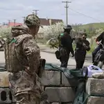 Un soldado ucraniano comprueba los documentos de identificación de dos civiles en la localidad de Vinogradnoye, cerca de Mariúpol, Ucrania