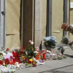 Una mujer deposita flores a las puertas del instituto Joan Fuster de Barcelona.