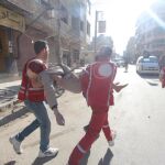 Miembros de la Media Luna Roja trasladan a un compañero herido en un bombardeo