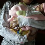 Una niña de 13 años sostiene a su bebé en brazos