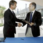 Francisco Camps y Knut Frostad se dan la mano tras firmar el acuerdo