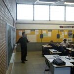 Un profesor da clase en un colegio concertado con el crucifijo en la pared