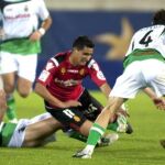 El centrocampista uruguayo del RCD Mallorca Gonzalo Castro (c) y el defensa del Racing de Santander Pablo Pinillos (d) luchan por el balón