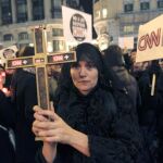 Una mujer vestida de negro porta una cruz durante la concentración en contra del cierre de CNN+ esta tarde en Madrid. Tras once años en antena y con una audiencia minoritaria pero fiel, CNN +