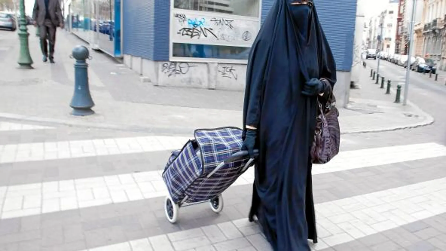 En la imagen, una mujer pasea por la vía pública ataviada con un burka