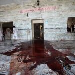 Unos paquistaníes limpian los restos que quedan en un templo después de un atentado bomba en la zona de Jamrud, Pakistán