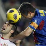 El delantero del Sevilla Álvaro Negredo (i) y el defensa del Levante Sergio Ballesteros (d), luchan por un remate de cabeza durante el partido correspondiente a la vigésima jornada de Liga en Primera División.