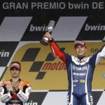 El rey Juan Carlos aplaude al piloto de MotoGP Jorge Lorenzo que celebra en el podio la victoria conseguida en el Gran Premio de España de su categoría, junto al segundo clasificado, Dani Pedrosa