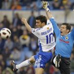 El centrocampista argentino del Real Zaragoza Nicolás Bertolo (i) disputa un balón con el portero del Racing de Santander Antonio Rodríguez "Toño"durante el partido correspondiente a la vigésimo segunda jornada del Campeonato Nacional de Liga de Primera