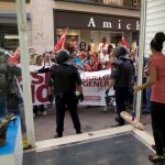 Una empleada de un negocio del centro de Sevilla, echa las persianas ante la presión de un piquete