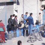 Un grupo de sirios, ayer, hace cola para cambiar bombonas de gas en un puesto callejero en la ciudad de Homs