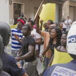 Un retén policial vigila a los manifestantes nigerianos que ayer protestaron por la muerte de su compatriota
