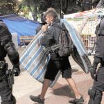 Un «irreductible» recoge sus pertenencias durante el desalojo de ayer de madrugada en plaza Catalunya.