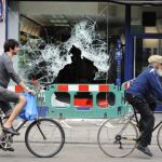 ersonas observan los daños provocados en el escaparate de un comercio durante los violentos altercados que se han vivido esta noche en Tottenham