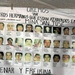 Un póster realizado por los familiares de los mineros muestra las imágenes de los 33 trabajadores atrapados