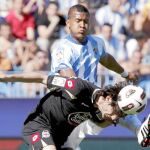 Colotto agacha la cabeza para despejar ante la entrada del delantero del Málaga, Rondón