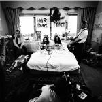 Foto titulada "En la cama" tomada por Gerry Deiter, donde se ve a Yoko Ono y John Lennon tocando la guitarra acústica en pijama en una cama en un hotel de Montreal en 1969, durante su segundo encierro de ocho días por la paz