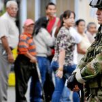 Un soldado vigila delante de una cola de electores que acudieron el domingo a votar en Corinto, al norte de Colombia