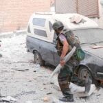 Un grupo de hombres de las fuerzas leales a Asad lucha contra los rebeldes en un barrio de Alepo