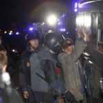 Uno de los concentrados se encara con la policía portando una nariz de payaso