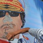 Un hombre destroza un mural en en el cuartel del 32 regimiento Khamis en Trípoli (Libia) después de su saqueo