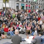 Los «indignados» contaron ayer en su asamblea-mitin con el ex fiscal Anticorrupción Carlos Jiménez (sentado y con micro en mano). Abajo, uno de los carteles que el 15-M pegará desde el viernes y en el que critican a los banqueros, en la imagen la pancart