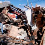 Un hombre camina sobre los restos de varias viviendas en Staten Island, Nueva York