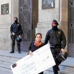 Una activista sale de la sede de CatalunyaCaixa con el cheque