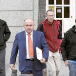 Los tres imputados, ayer, junto a su abogado, antes de comparecer ante el juez