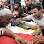 En el funeral de las 16 víctimas se oyeron gritos contra Mursi. En la imagen, un grupo de familiares llora sobre el ataúd de uno de los soldados fallecidos