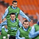 Pedro, que puede ser titular, salta al fondo de la imagen. Delante, Xavi y Cazorla